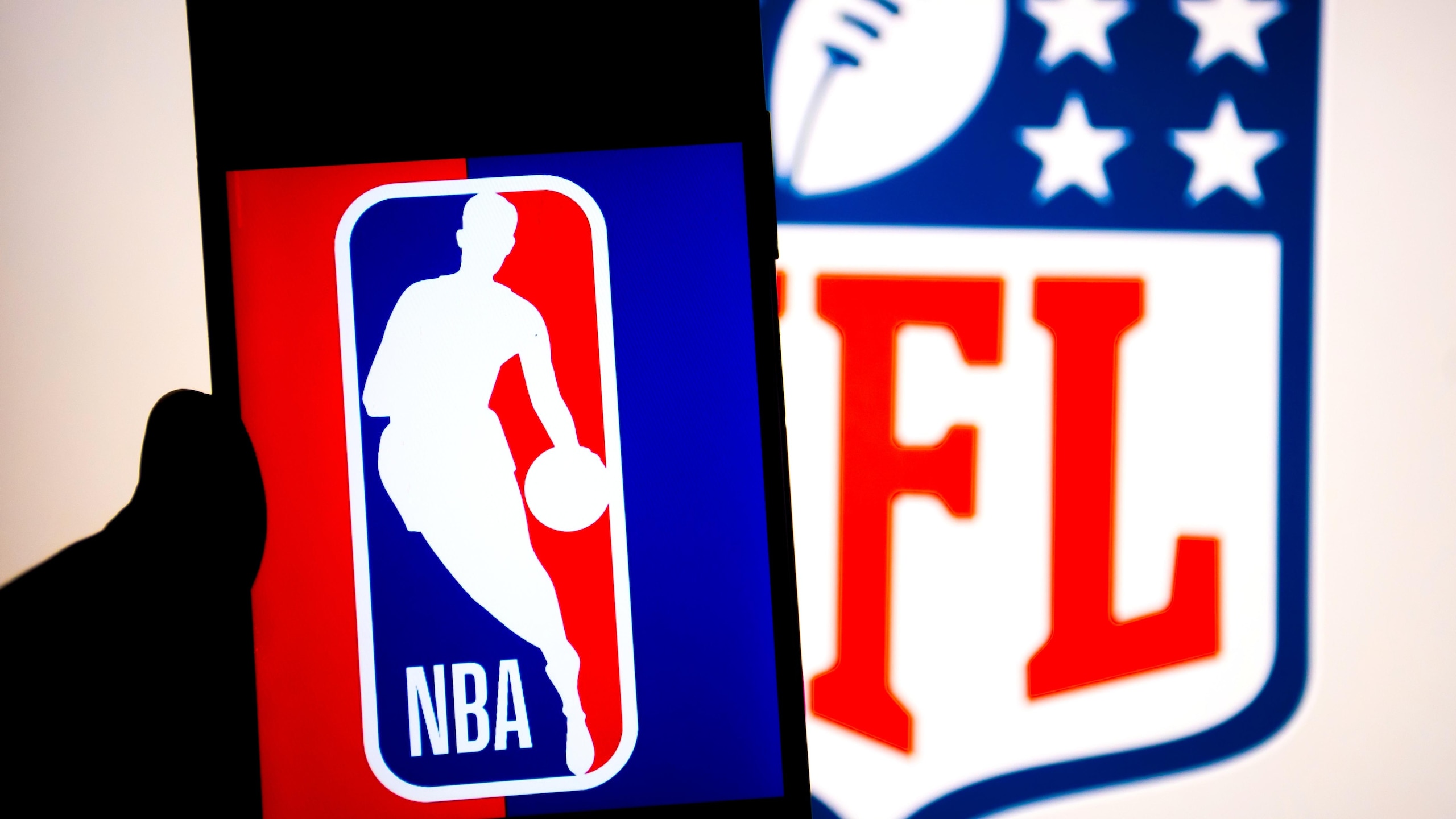 In this photo illustration, a NBA logo seen displayed on a