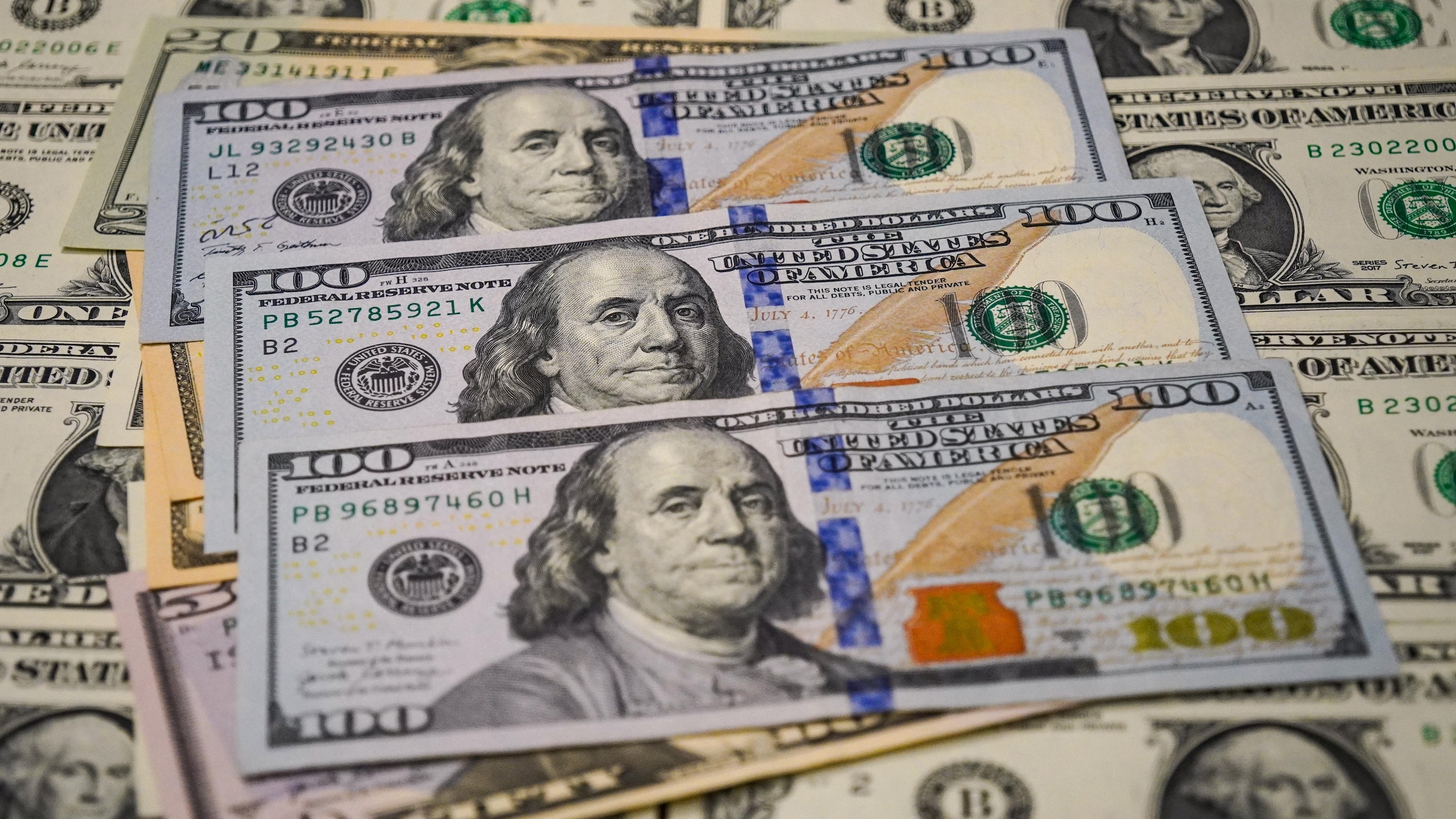 In this photo illustration, a view of $100 bills seen In this photo illustration, a view of $100 bills seen