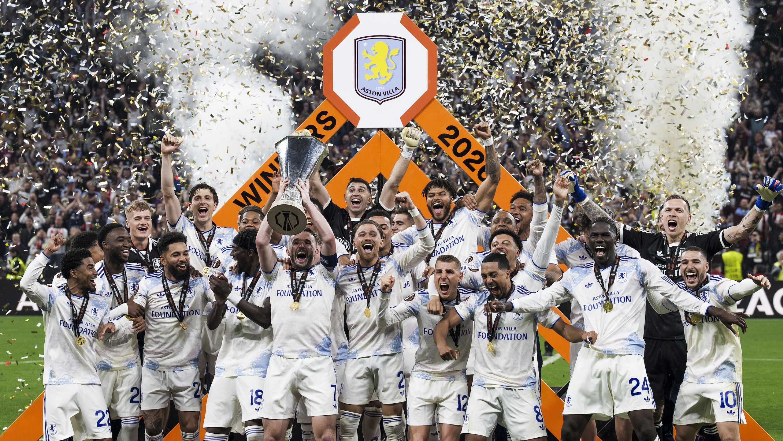 John McGinn (C) of Aston Villa FC lifts the trophy as