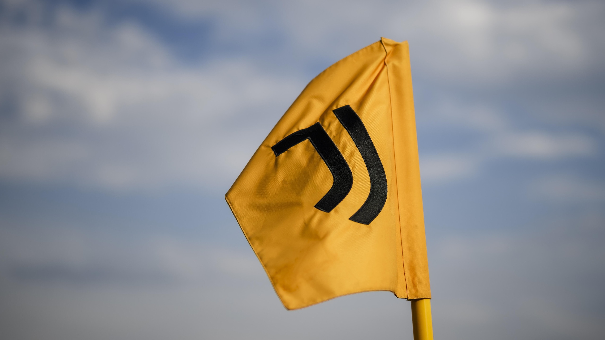 A corner flag bearing the logo of Juventus FC waves during