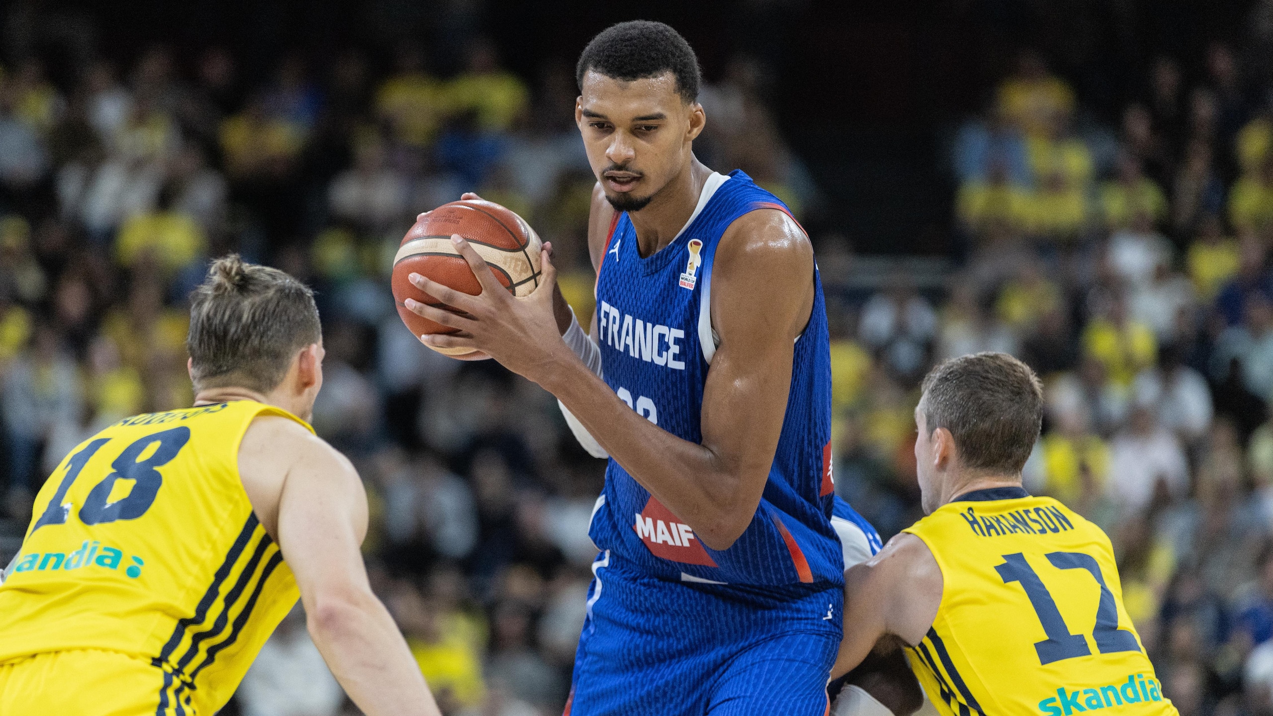 Victor Wembanyama of France (C) and Viktor Gaddefors (L) and