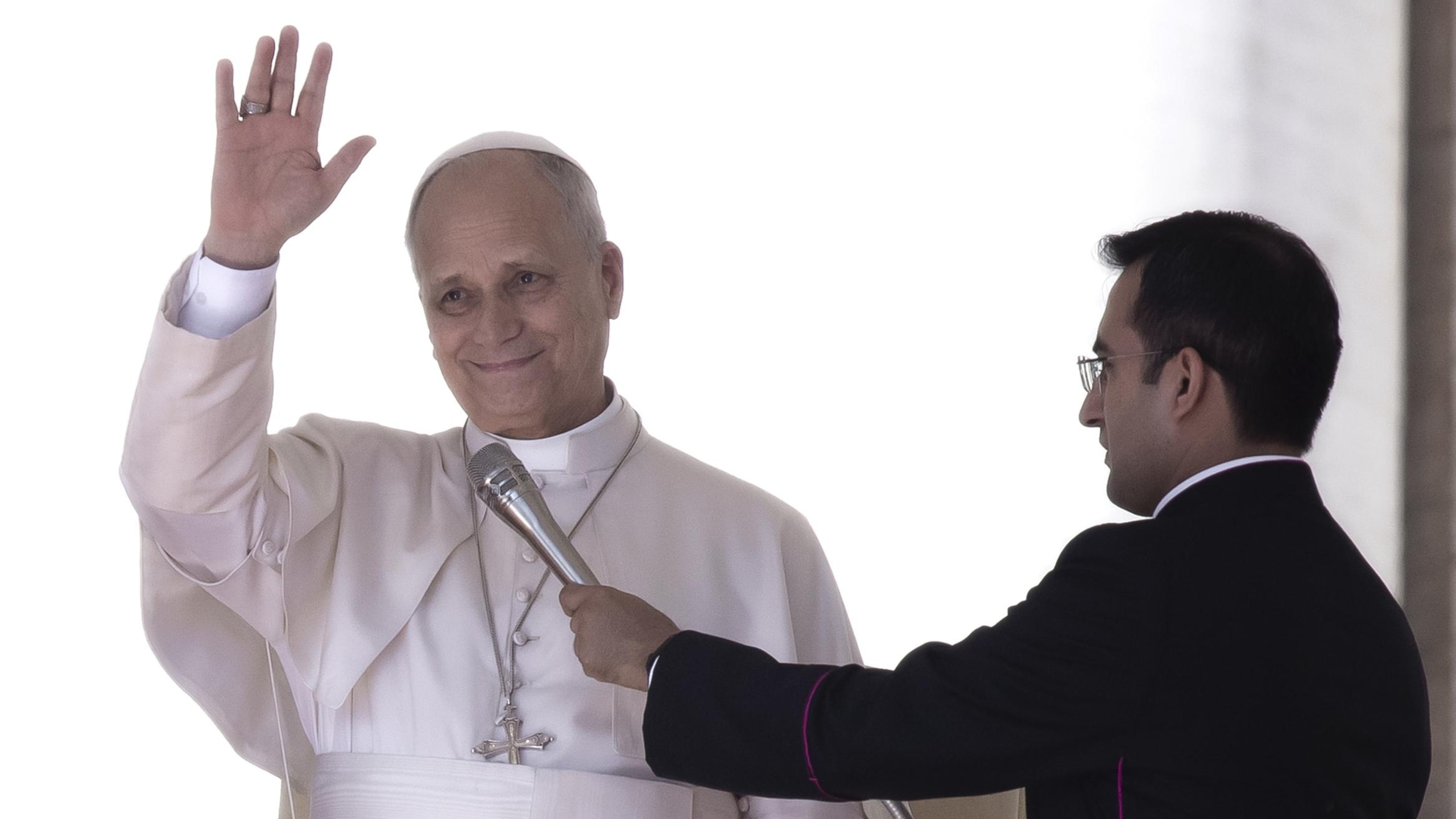 Pope Leo XIV waves while his secretary, Monsignor Edgard Iv