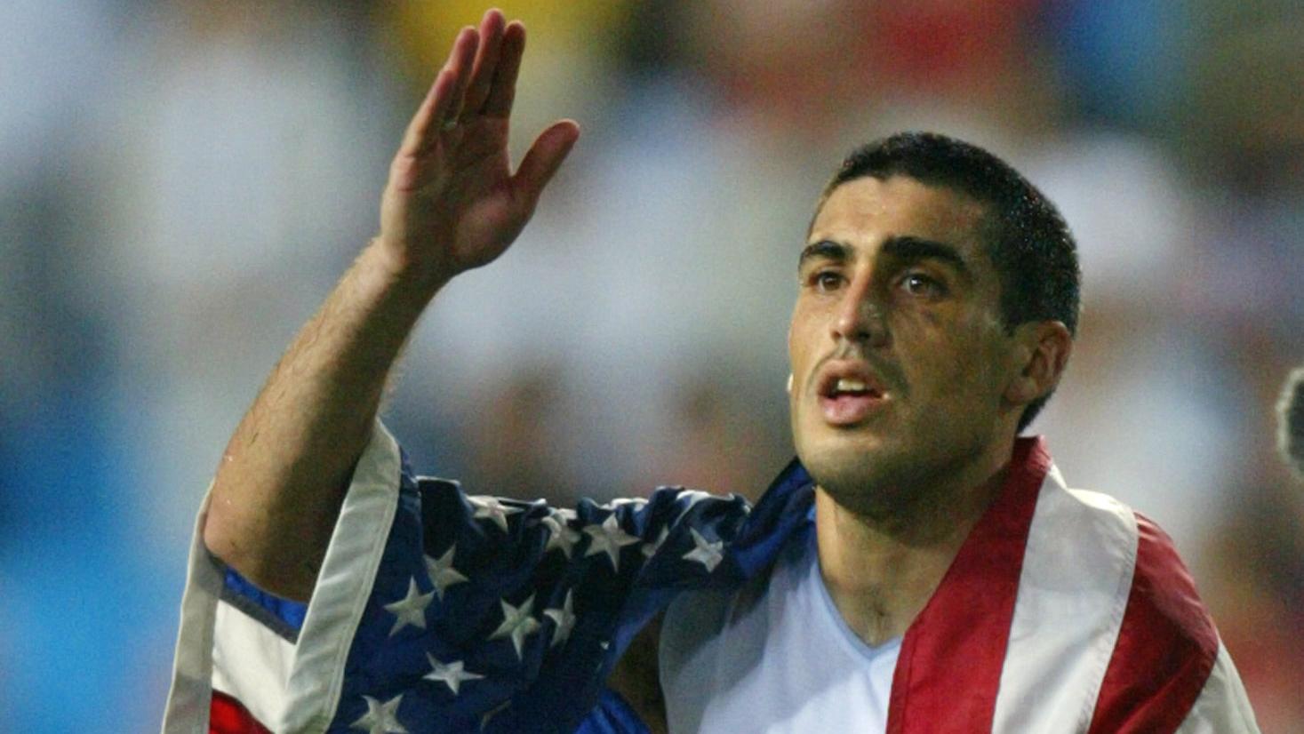 USA captain Claudio Reyna drapes himself in an Ame