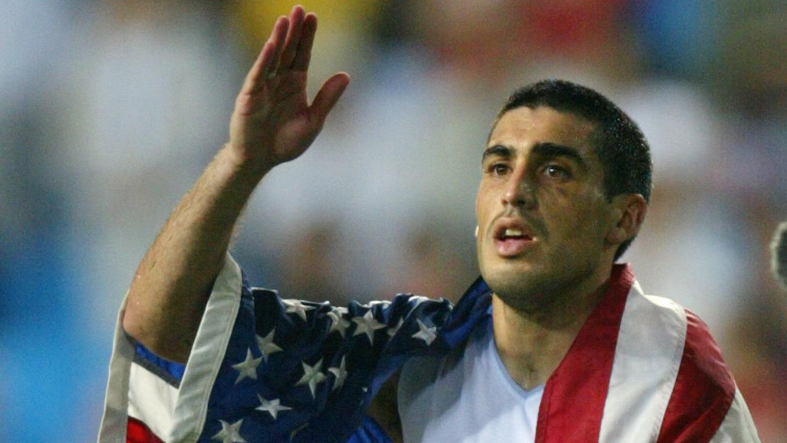 USA captain Claudio Reyna drapes himself in an Ame