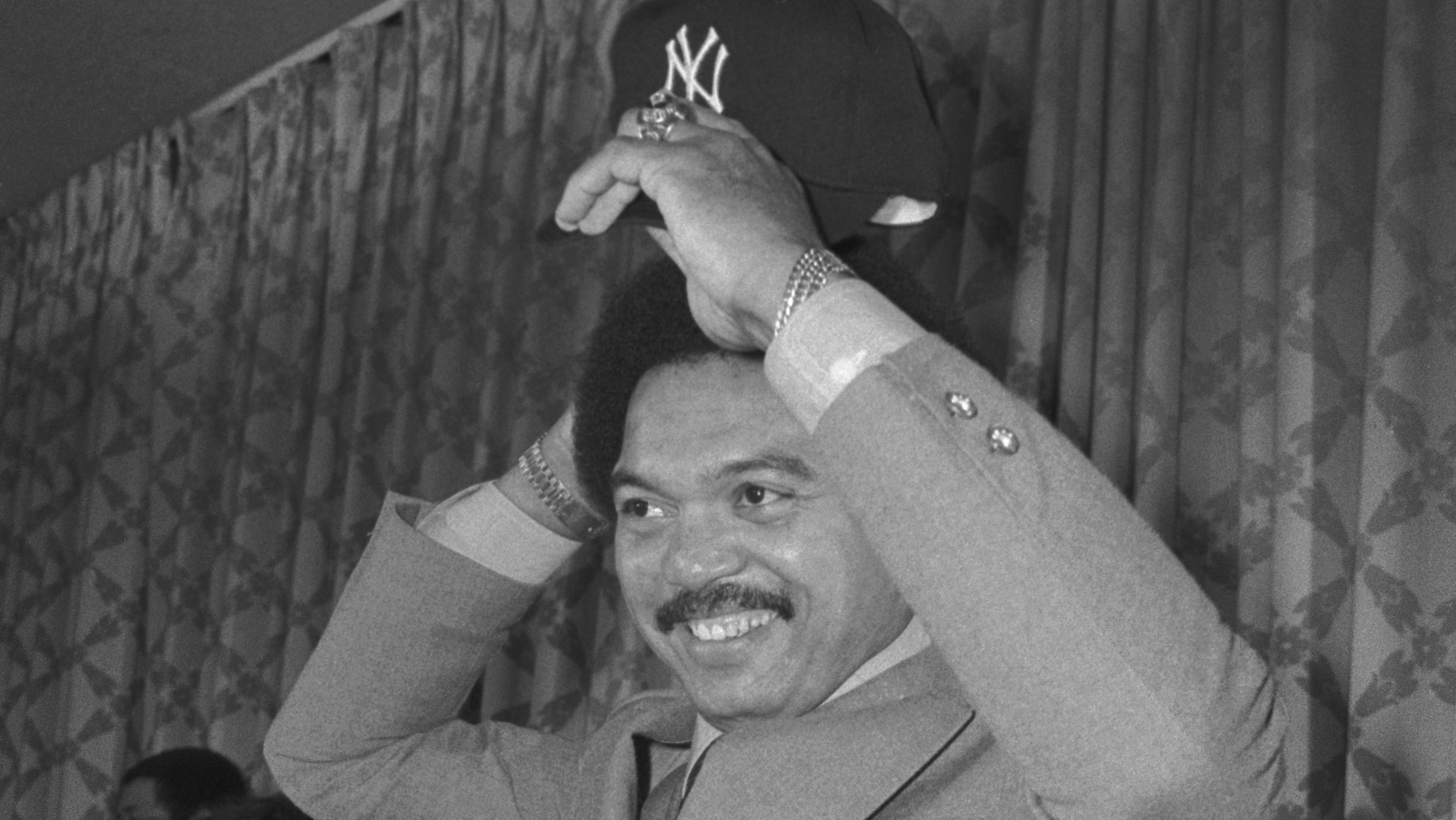 Reggie Jackson Putting on Yankee Hat