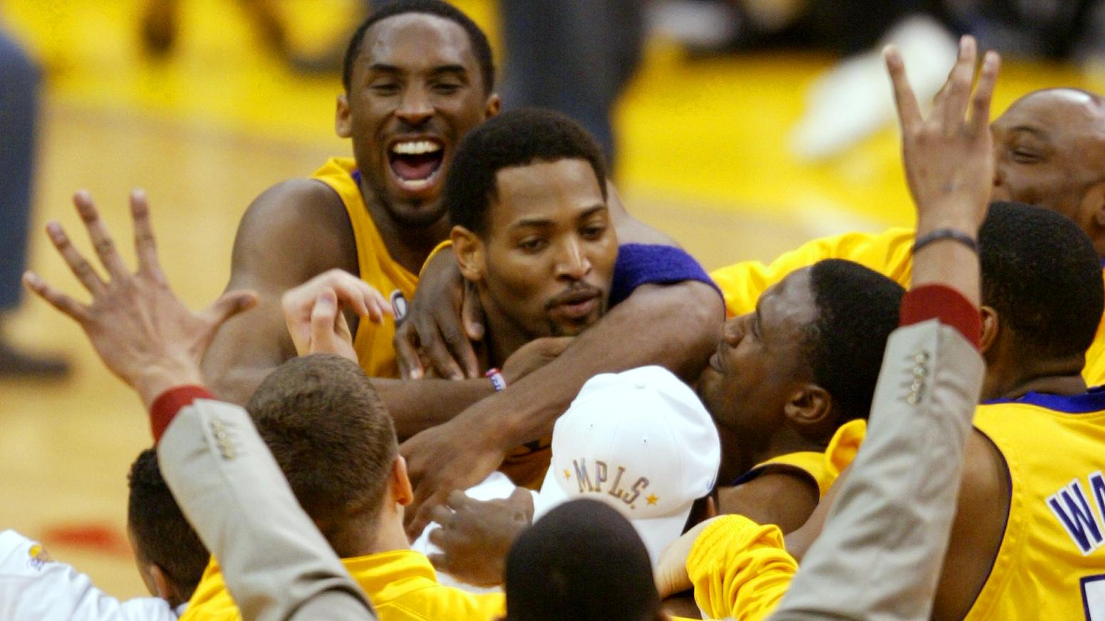 Lakers Kobe Braynt and teammates swarm Robert Horry after Horry sunk the game winning 3point shot t